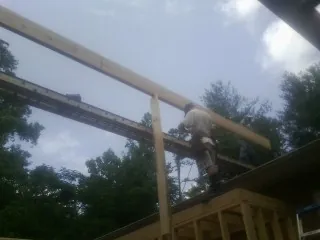 Carpenter setting a ridge beam over a new addition frame — Ice Dam Removal by Roofing Brothers in Lynn Haven