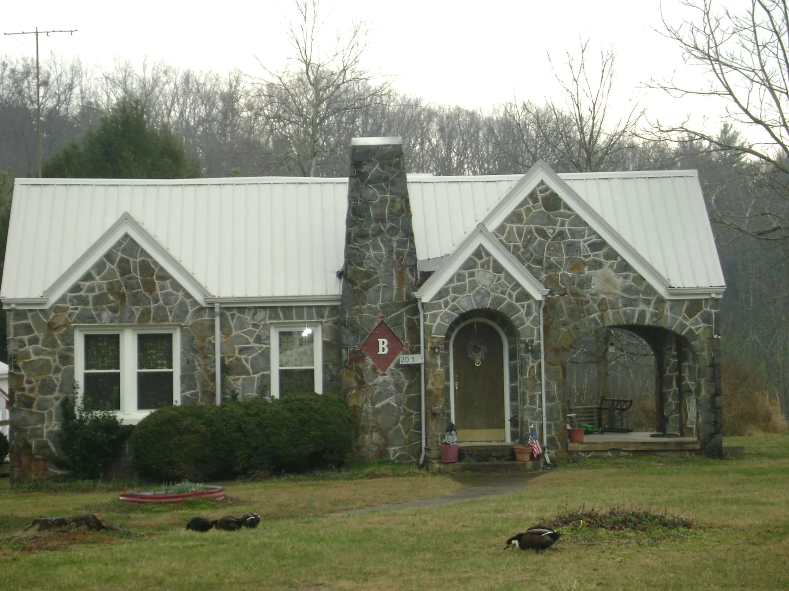 White metal roof on a stone cottage with steep gables in Lynn Haven