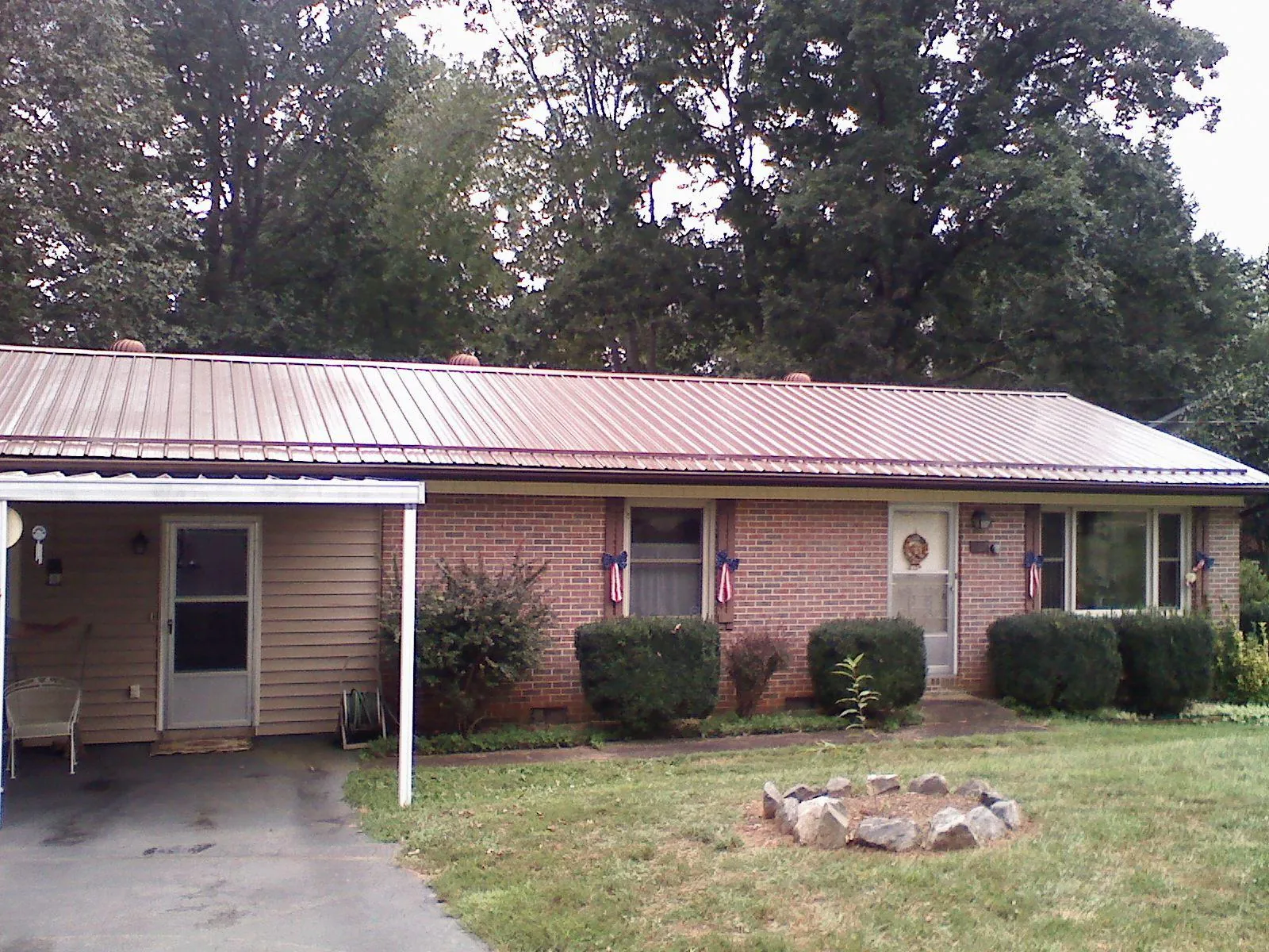 Bronze metal roof and carport on a brick ranch home — Roof Repair work by our crew in Lynn Haven