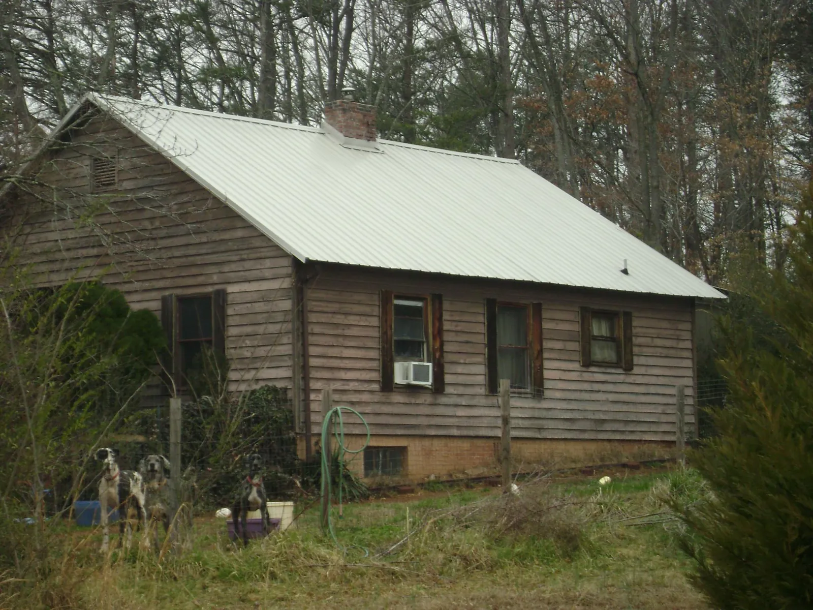 White metal roof on an old wood sided farmhouse, from a Metal Roof Installation job in Lynn Haven